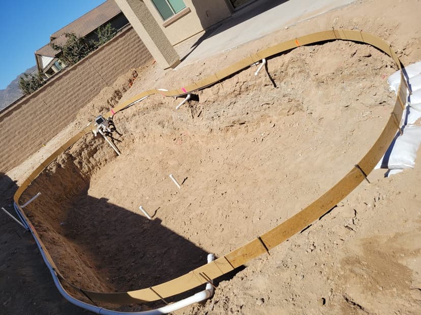Freeform pool excavation with plumbing stub-outs and wood forms